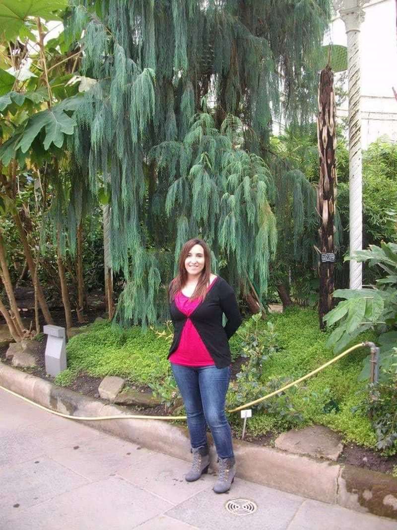 A woman in a lush botanical garden, potentially on a cultural excursion.