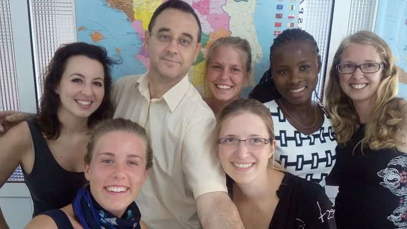 Group of international students posing in front of a world map.