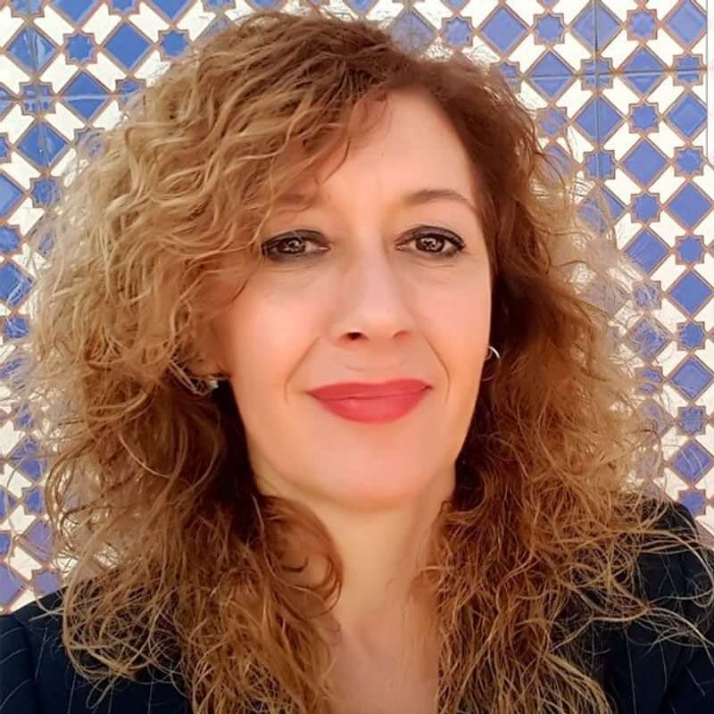 A woman in front of a tiled wall, potentially in Spain.