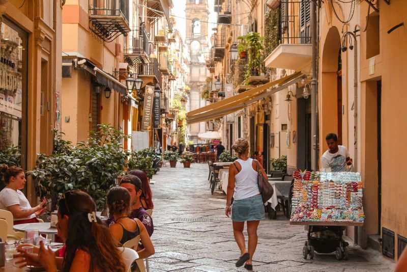 People dining in a charming European street, exploring local culture, language.