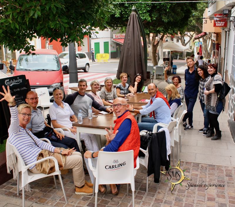 Group of people enjoying dining outdoors, possibly language travel group.