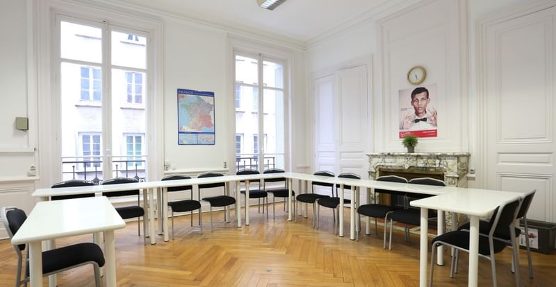 Classroom for language learning with desks, chairs, and educational posters.