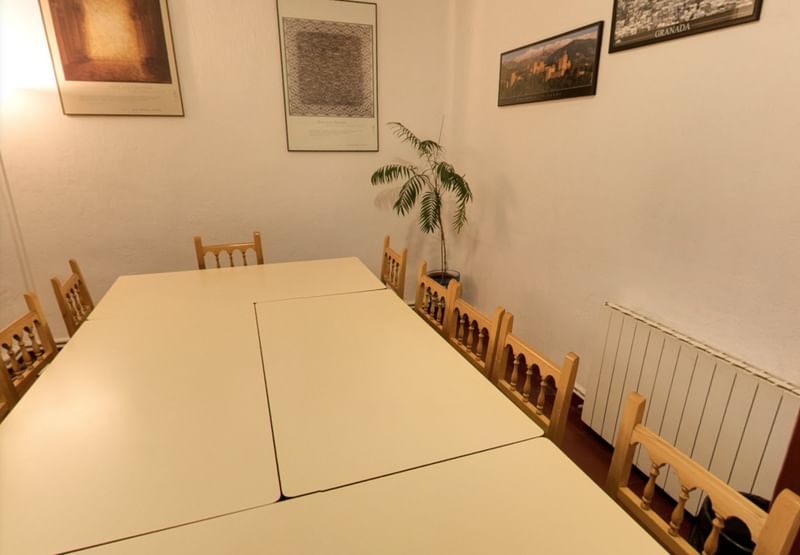 Vergaderruimte met tafels en stoelen in een culturele taalreisomgeving.