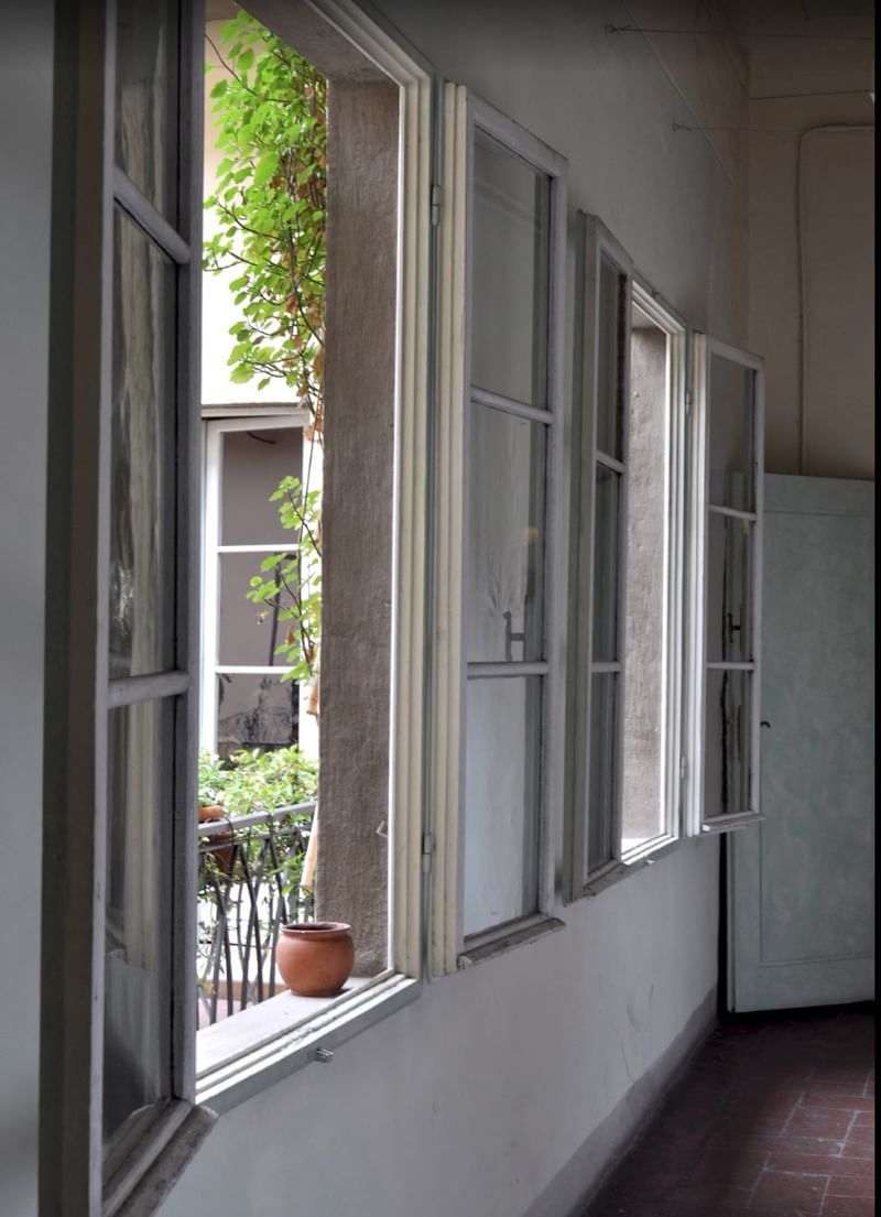 Open ramen met uitzicht op een binnenplaats met groen.
