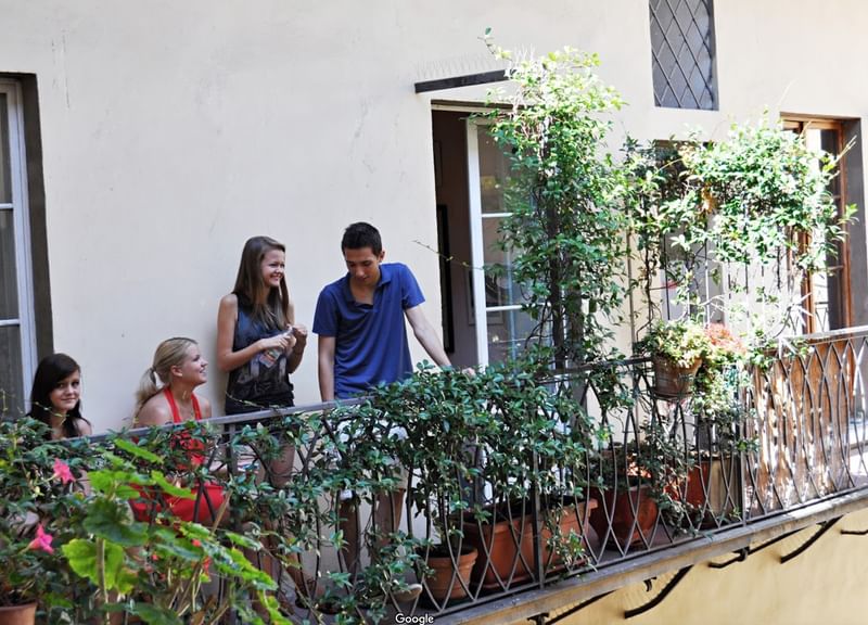 Studenten op een balkon socialiseren tijdens een taalreis in het buitenland.