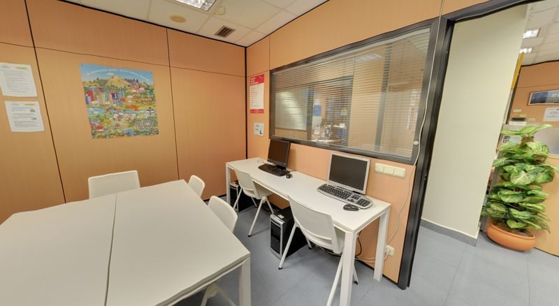Language learning lab with desks, computers, and study materials.