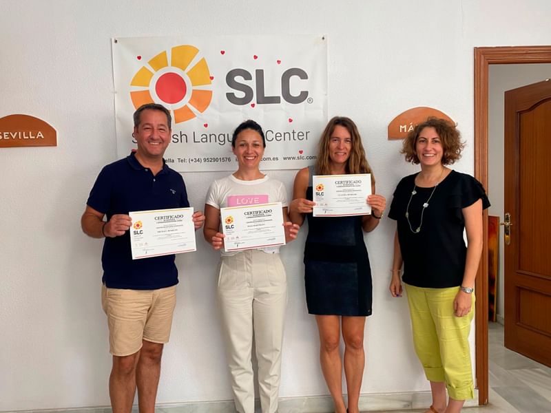 Personen poseren met certificaten in taalschool na voltooiing cursus Spaans.