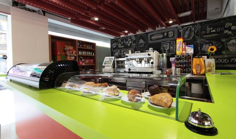 Een kleurrijke bakkerij met verschillende gebakjes en een koffiemachine.