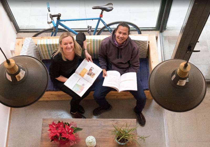 Two people studying languages together in a cozy, modern setting.