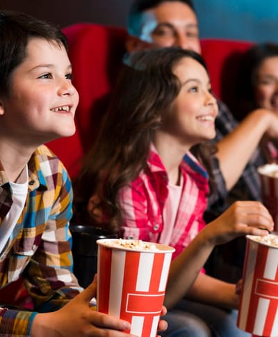 Gelukkige familie zitten in de bioscoop