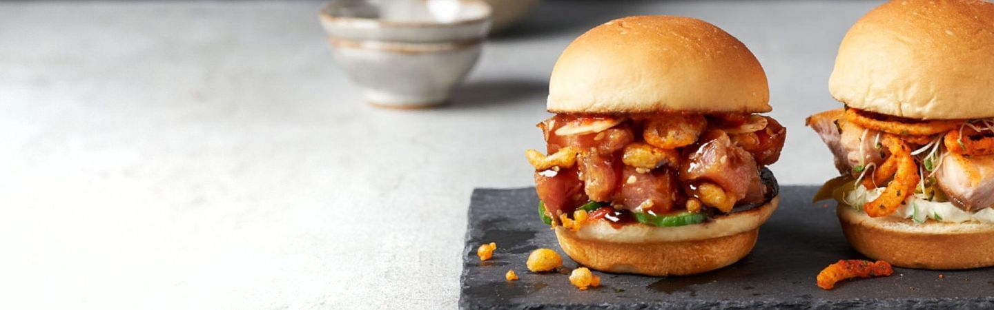 Sushi sliders on slate platter on white surface