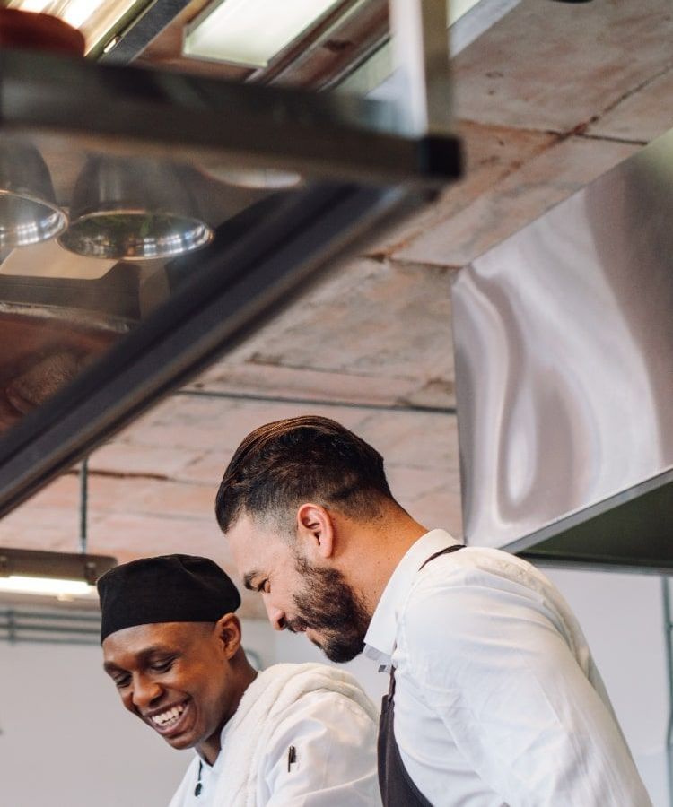 Two chefs working together in a commercial kitchen.