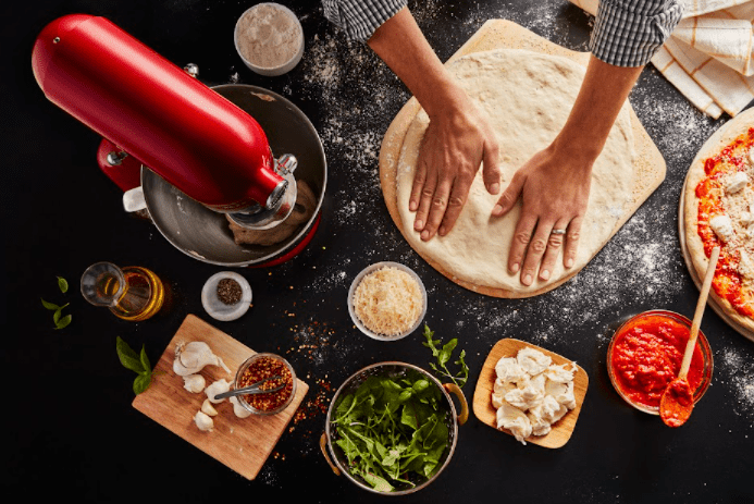 melhor batedeira - Batedeira KitchenAid Artisan vista de cima juntamente ao preparo de pizza.