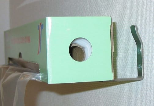 Vägghållare till förkläde på rulle metall