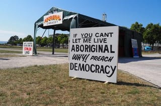 <span class="artist">Richard Bell</span><span class="title"> Embassy</span><span class="year"> 2013-ongoing</span>, <span class="medium">canvas tent with annex, aluminium frame, rope, synthetic polymer paint on ply; video</span>, <span class="dimen dimen-notes">Dimensions variable</span>, <span class="notes">Installation view, documenta15, Friedrichsplatz, Kassel</span>