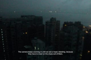 <span class="artist">Tintin Wulia</span><span class="title"> A Thousand and One Martian Nights (still)</span><span class="year"> 2017</span>, <span class="medium">Single-channel video projection, surveillance camera, telematic structure, screening room</span>, <span class="dimen dimen-notes">38:01 min, dimensions variable</span>