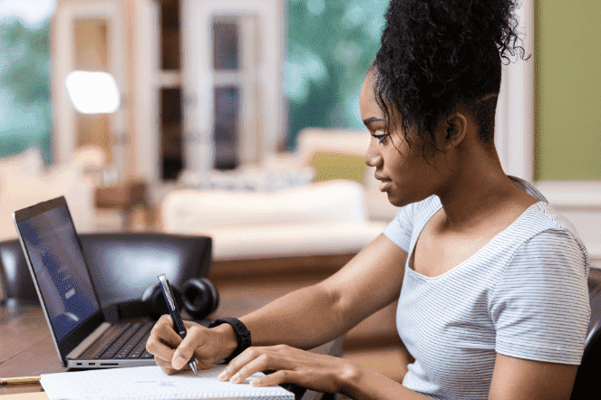 Adolescente negra estudando na frente do computador