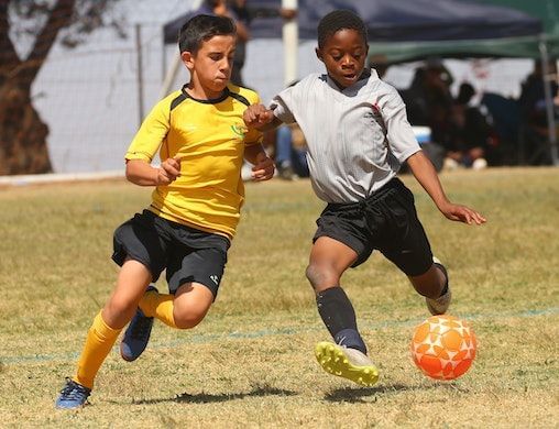 Dois meninos jogando futebol; Dicas para aproveitar a Copa do Mundo com as crianças