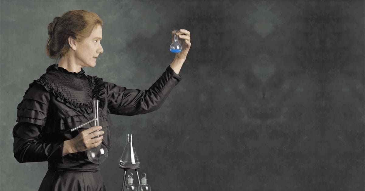 Mulher com trajes antigos segurando vidrarias de química e olhando fixamente para elas; mulheres cientistas: veja 6 pioneiras que mudaram o mundo da ciência