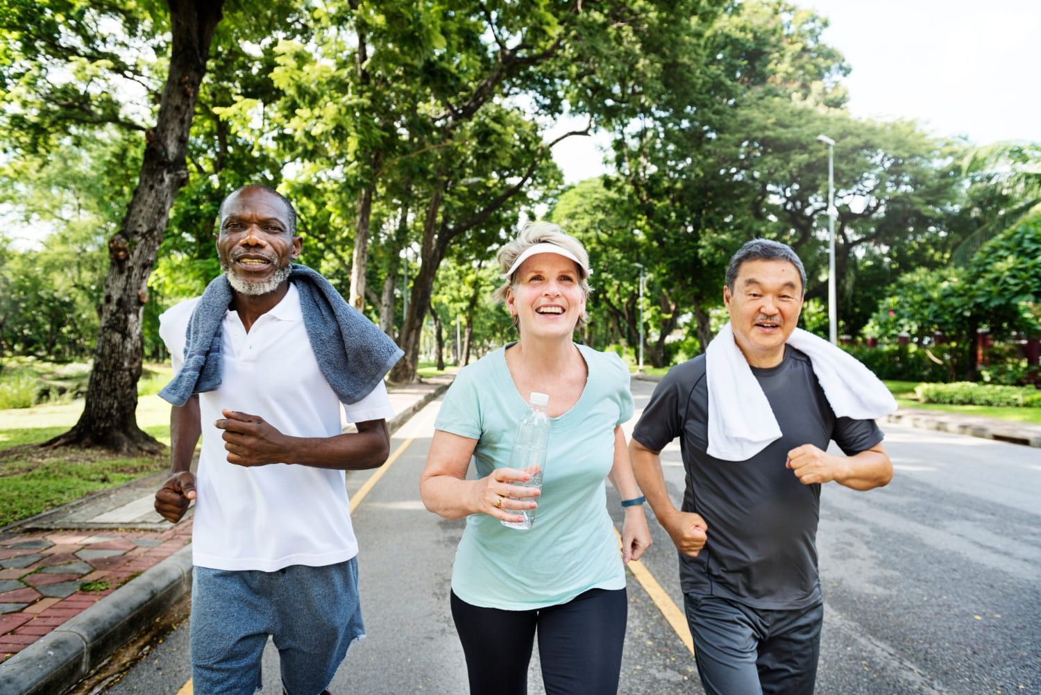 Grupo de três idosos correndo no parque; confira citações sobre saúde para usar na redação