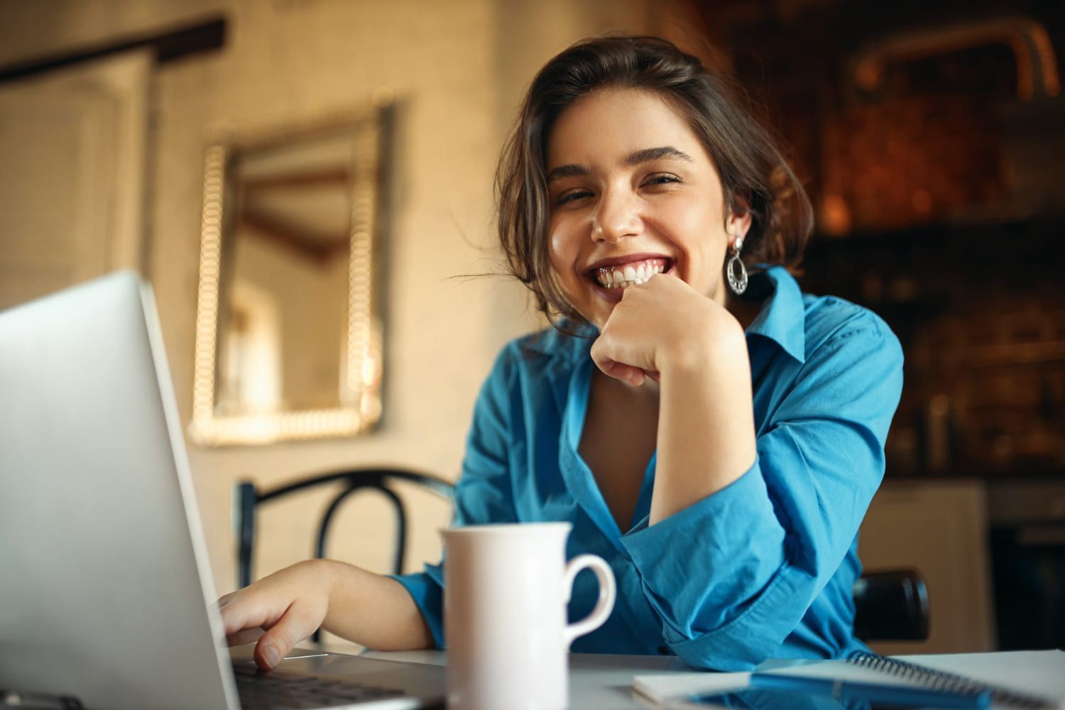 mulher feliz em frente ao computador; Concurso Nacional Unificado: 10 cursos com mais vagas