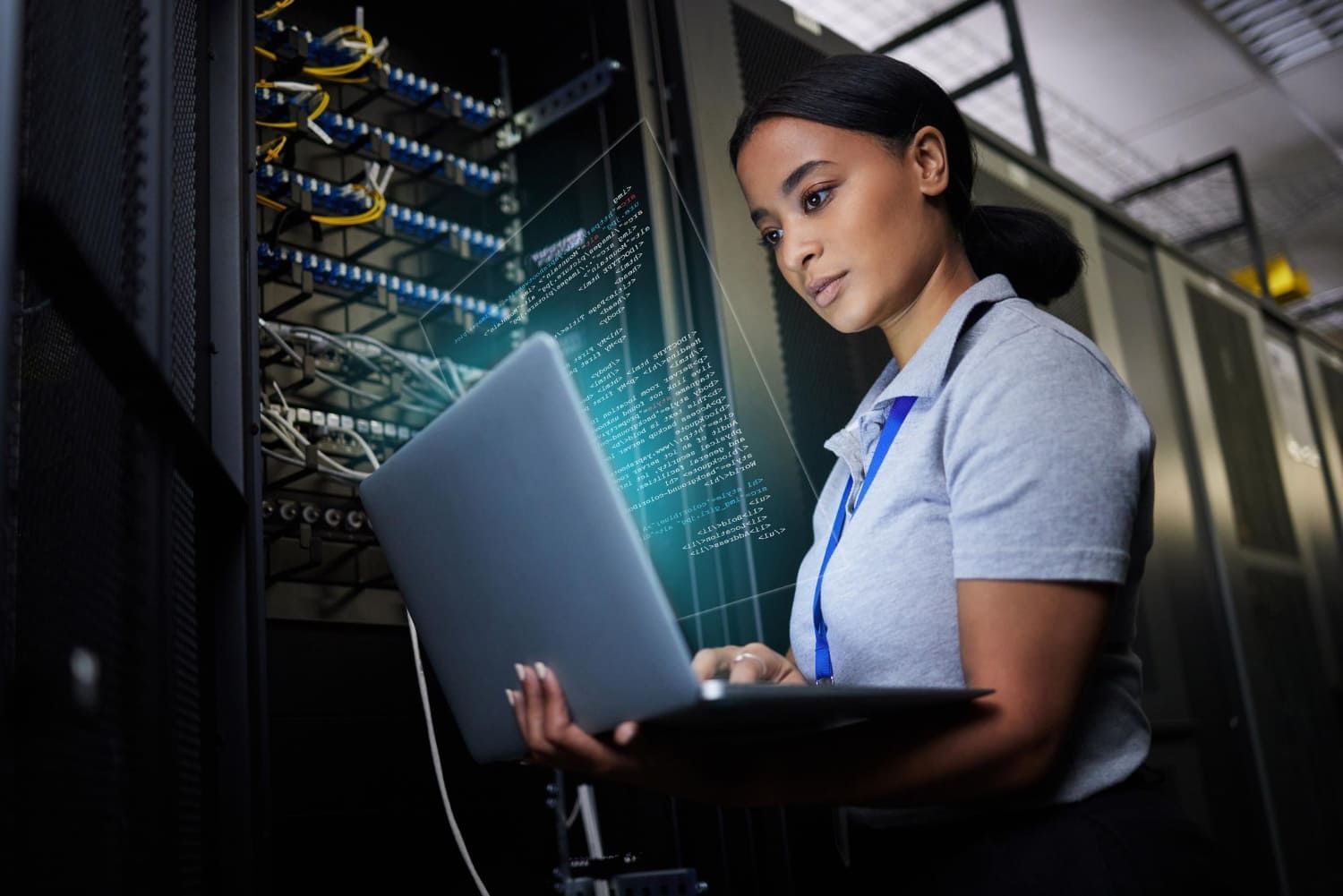 Mulher negra em uma sala de servidores solucionando problemas de programação e segurança cibernética; Melhores faculdades privadas de Sistemas de Informação