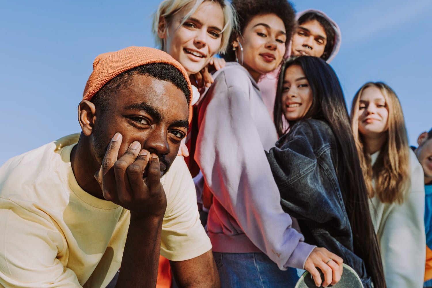 Grupo multicultural de jovens amigos se unindo ao ar livre e se divertindo; entenda quem é geração X ou Y e qual o seu perfil