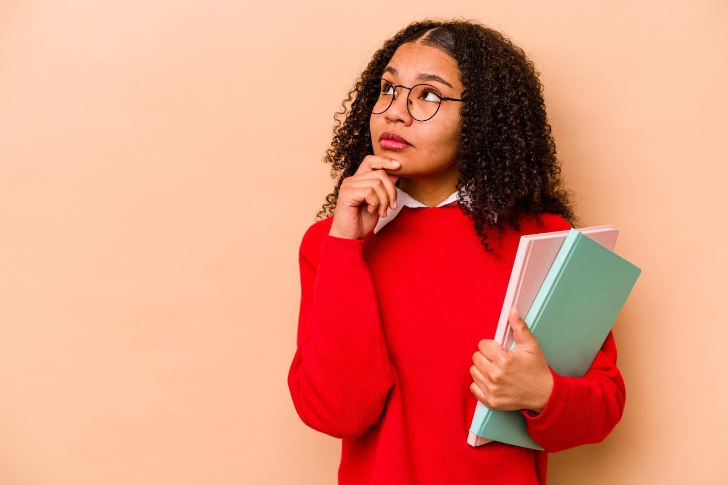 Jovem estudante olhando de lado com expressão duvidosa e cética e pensando quando sai o edital do enem 2024