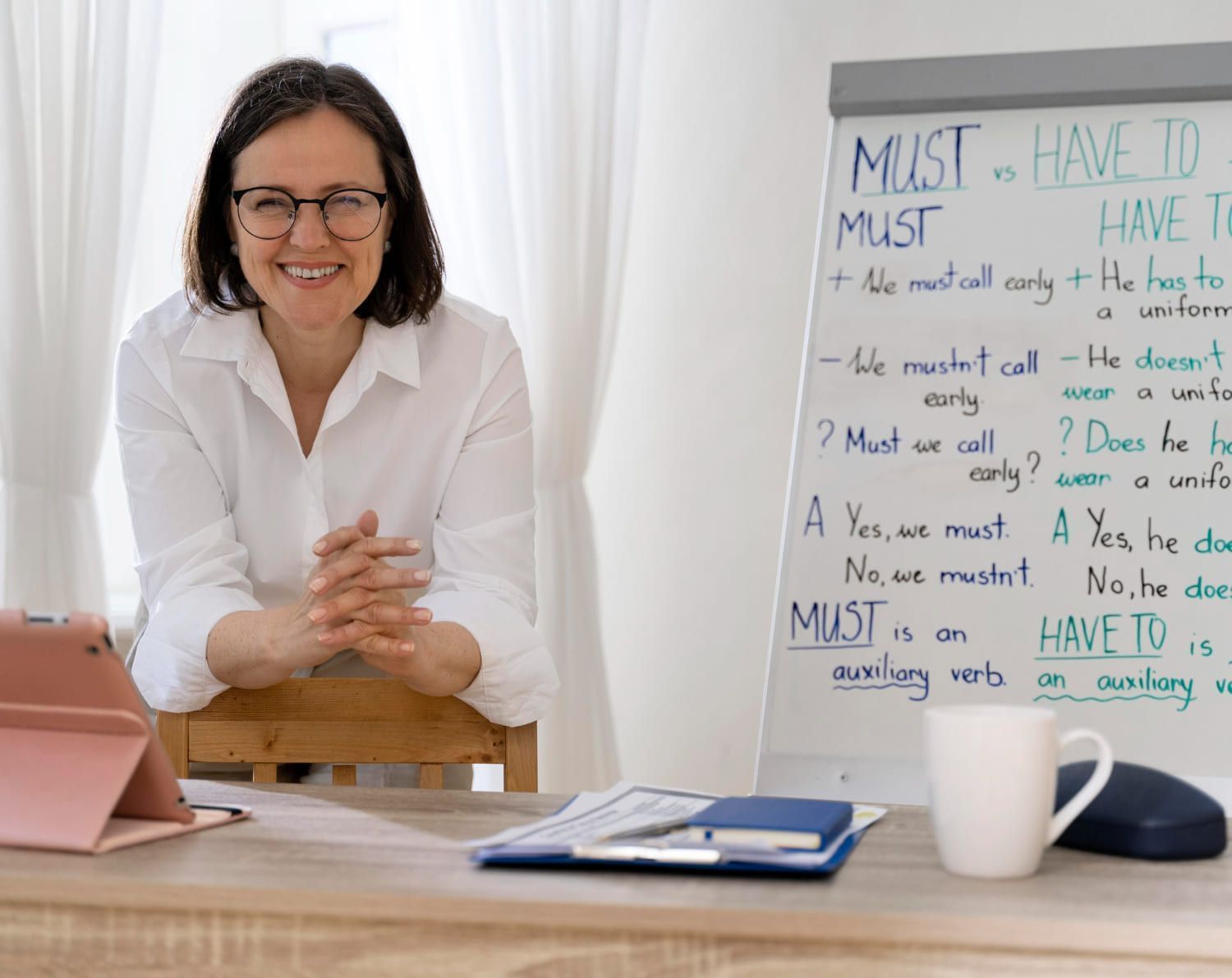 Professora de inglês dando aula com um quadro branco sobre adjetivos