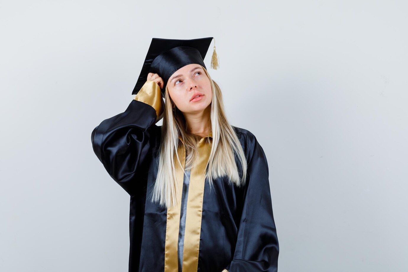 Mulher branca, loira, com roupa de formatura ponderando entre pós-graduação e especialização técnica