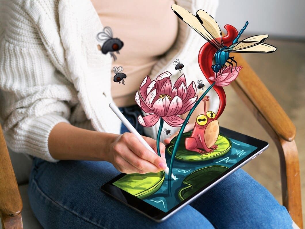 Designer Gráfico trabalhando num tablet com realizando desenhos e animações 3D, os objetos e elementos saem da tela e ganham vida