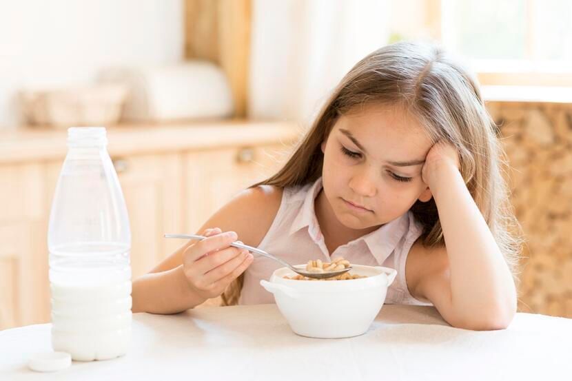 criança comendo cereal com leite