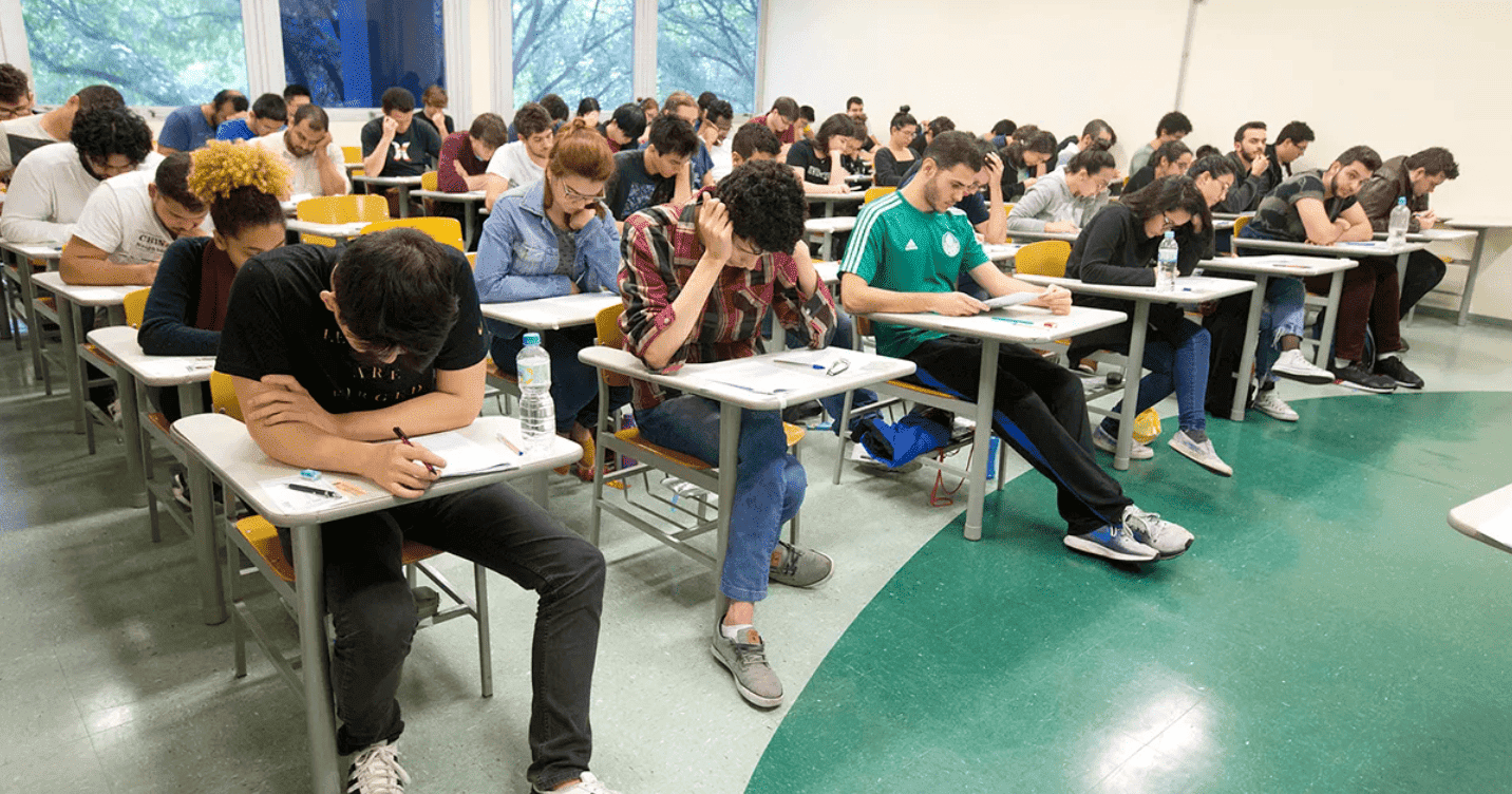 Estudantes sentados nas carteiras na sala de aula fazendo a prova do vestibular da USP, a Fuvest; saiba que horas começam as inscrições para a fuvest