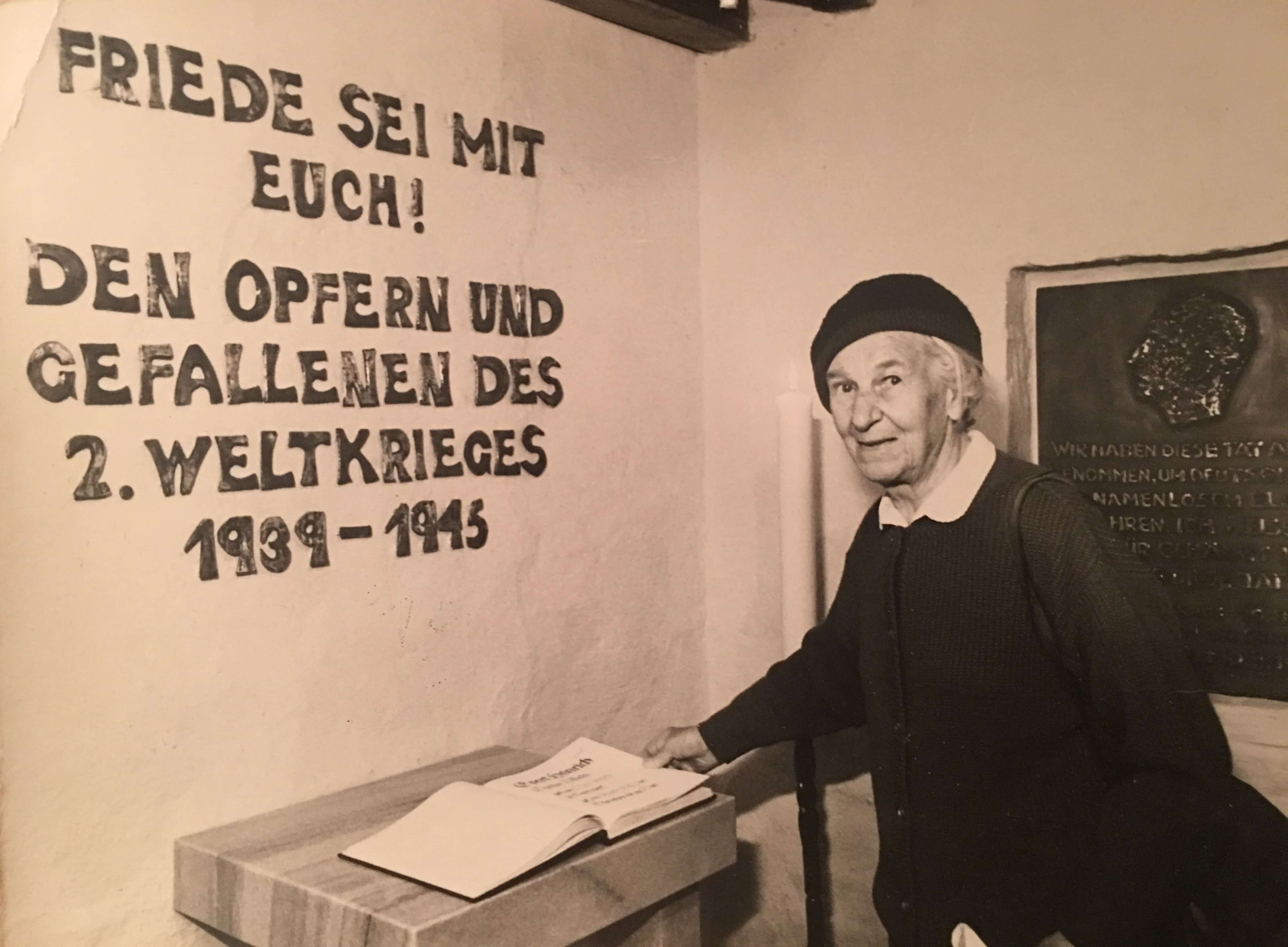 6 Tisa von der Schulenburg in der nahegelegenen Gressower Dorfkirche, hinter ihr die Gedenkplatte, die sie f&uuml;r ihren Bruder angefertigt hat.