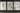 A photograph of an art installation, viewed through a window from outside a building. The installation consists of three large white plinths which display artworks including textile objects, black and white photographic prints and a text work. It is dark outside and the installation is lit so it can be viewed.