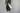 A handmade clay chain is hanging in front of a wall. A single white candle is placed within the chain facing outwards.