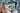 A photograph of a section of a painting. The work fills the image, and consists of various painted elements that have been cut up and collaged together, including three figures, two of which are wearing armour, a black cat, framed pictures, a candlestick and a door.