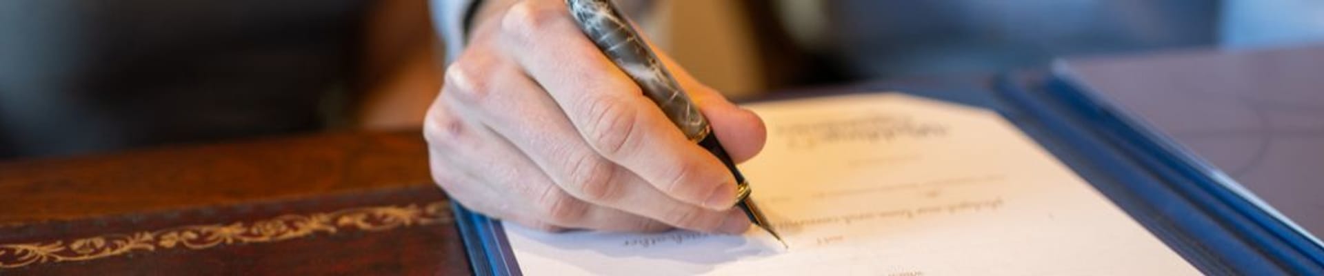 Decorative image to show a person signing a document