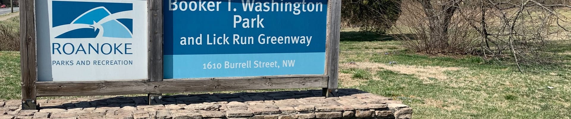 A photograph of the park Booker T. Washington Park and Lick Run Greenway Park sign at 1610 Burrell Street, NW