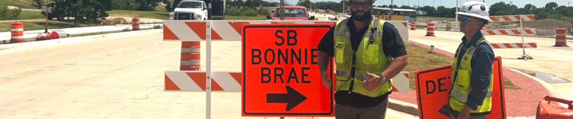 2 men installing southbound Bonnie Brae directional arrow sign