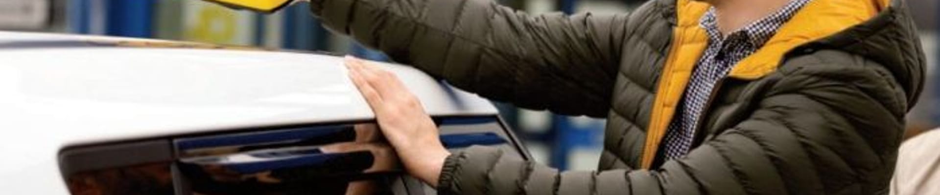 A man places a taxi sign on the roof of a vehicle