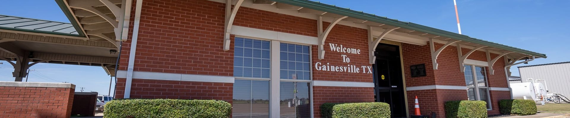 Building that has a sign that says "Welcome to Gainesville, TX"