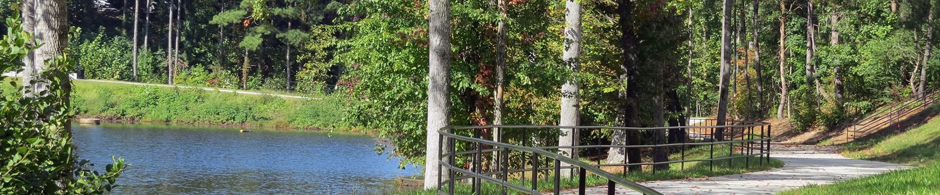 Image of multi use trail with lake and barrier fence