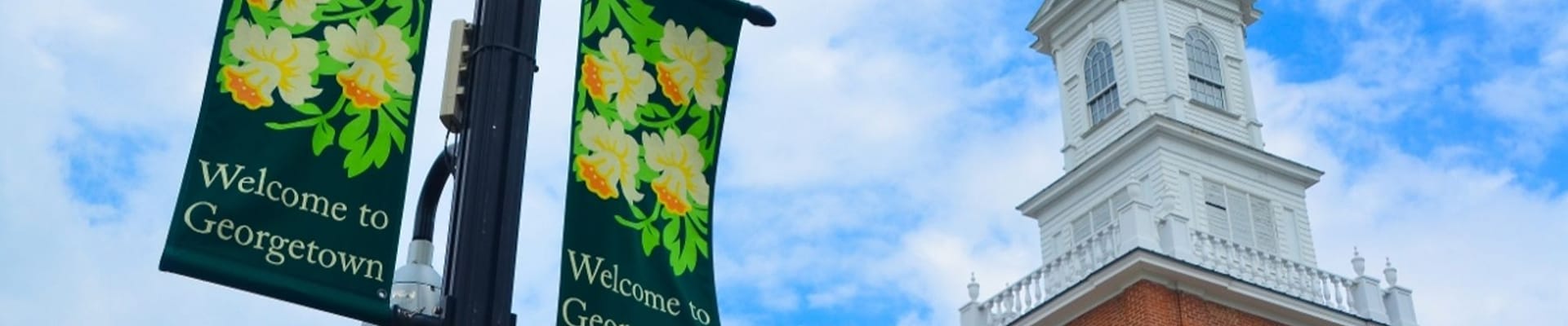 A photo of banners and Sussex County Courthouse with the logo of the Town of Georgetown