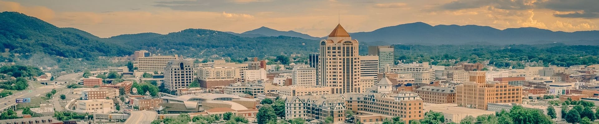 CIty of Roanoke Skyline with Hotel Roanoke and the Wells Fargo building in the foreground and blue ridge mountains in the background
