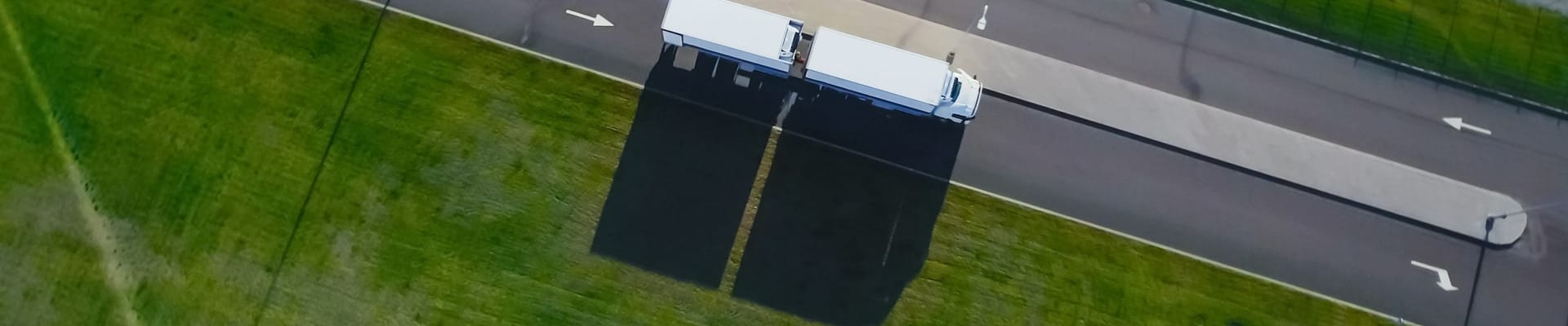 Aerial view of four lane divided road with semi truck.