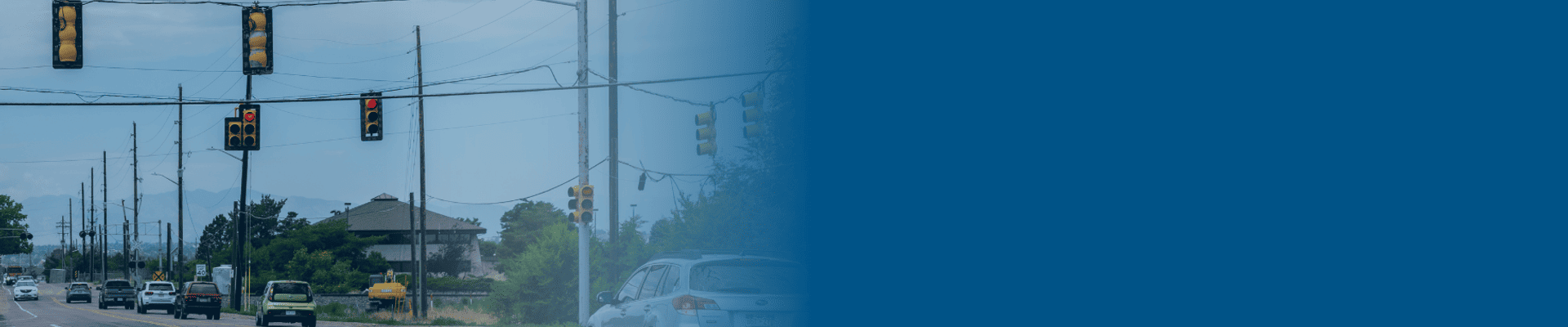 People driving on a road with stoplights at the top.