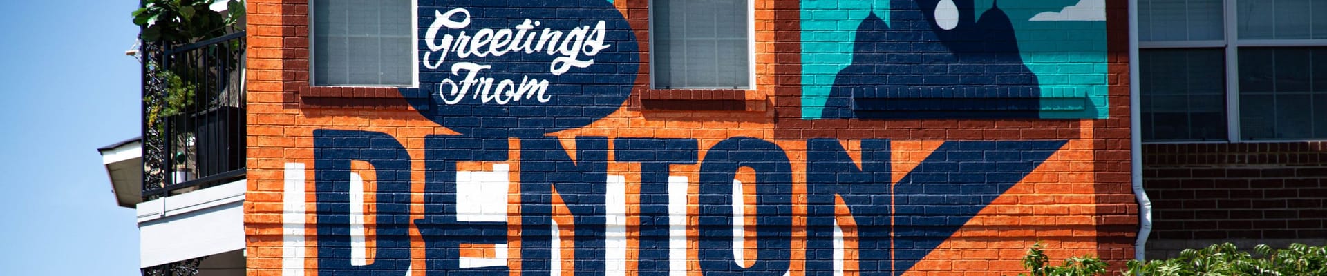 Mural on a building that says "Greetings from DENTON"