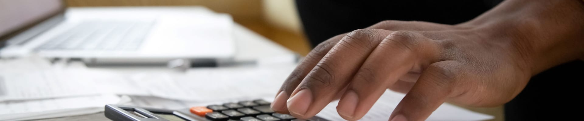 man paying bills using calculator