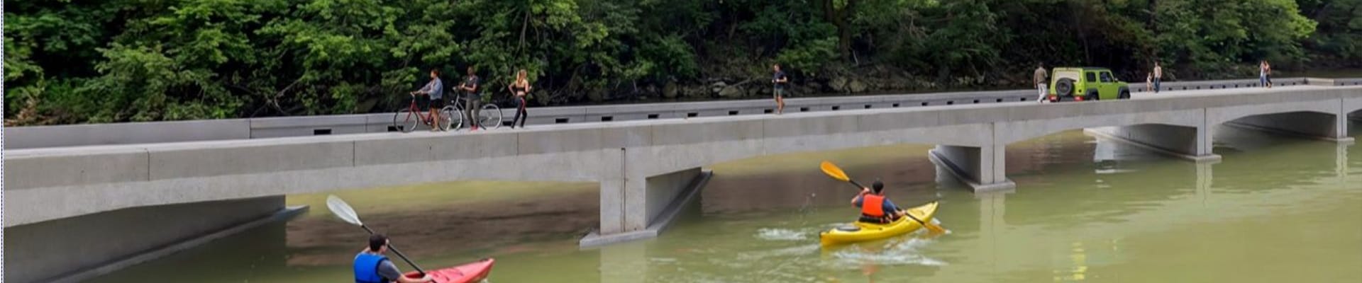 Rendering of a new low water bridge on wiley drive over the river with pedestrian, cycle, and vehicular traffic on the bridge and kayakers moving under the bridge
